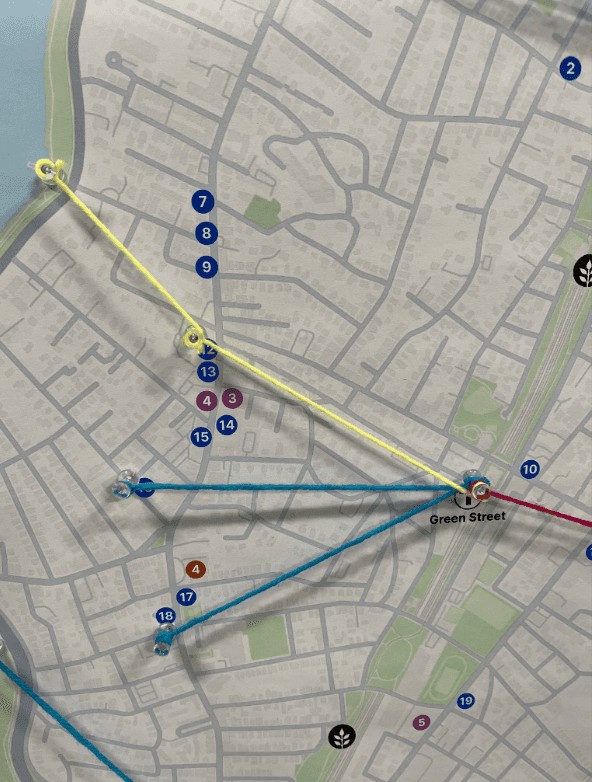Business locations on a physical map board, connected with colored threads